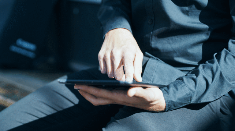 homem com tablet no colo usando ferramentas de melhoria contínua